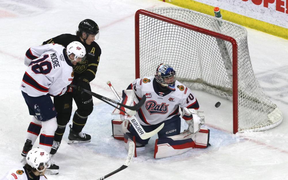 Regina Pats goalie Ewan Huet (70) makes a save as Brandon Wheat Kings forward Caleb Hadland (10) and Regina forward Zach Moore (18) watch the puck bounce into the air during the first period of their Western Hockey League game on Friday at Westoba Place. (Perry Bergson/The Brandon Sun)