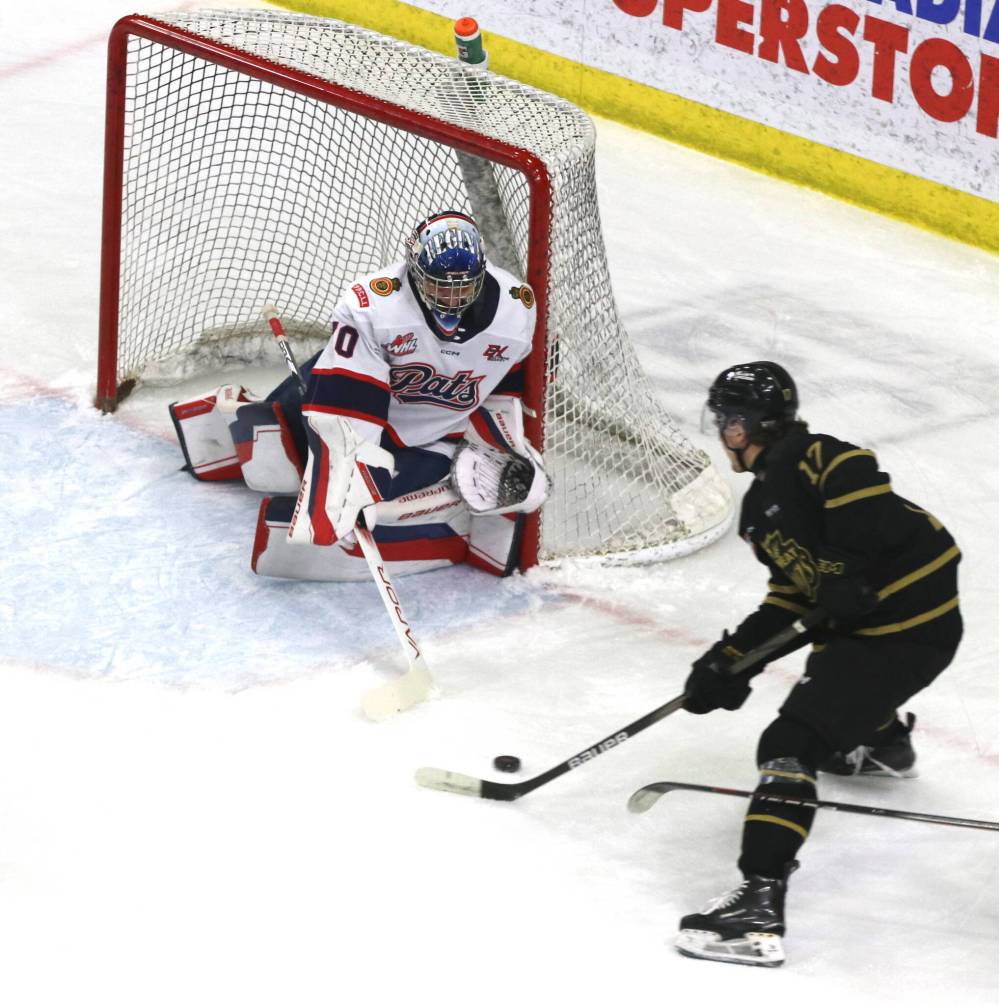 Regina Pats goalie Ewan Huet (70) watches as Brandon Wheat Kings forward Joby Baumuller (17) skates out in front with the puck during the first period of Friday’s game. (Perry Bergson/The Brandon Sun)