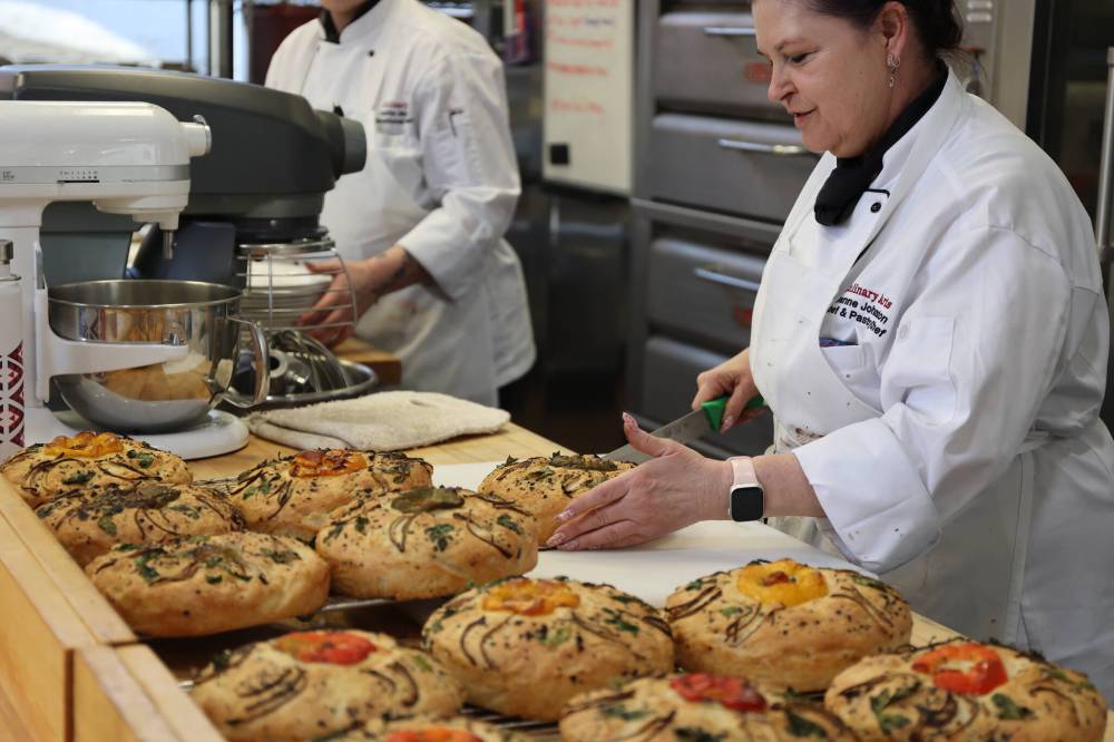 Joanne Johnson, instructor in Assiniboine College’s baking foundations program, slices the focaccia bread for those attending the Foundation Legacy Gala. (Michele McDougall/The Brandon Sun)