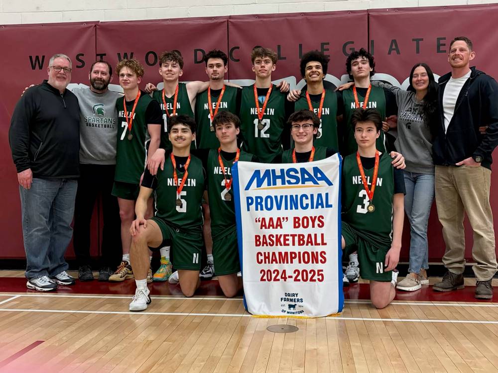 Members of the Neelin Spartans boys basketball team pose with the AAA basketball provincial championship banner following Saturday's 76-70 win. (Submitted)