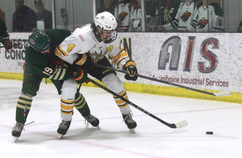 Under-18 AAA Brandon Wheat Kings defenceman Nolan Saunderson (4) tries to carry the puck out from behind his net as Winnipeg Wild forward Reid McIntyre (19) interrupts his progress during the second period of Game 3 of the Manitoba U18 AAA Hockey League final on Wednesday evening. The game ended after deadline with the Wild holding a 2-0 series lead. (Perry Bergson/The Brandon Sun)