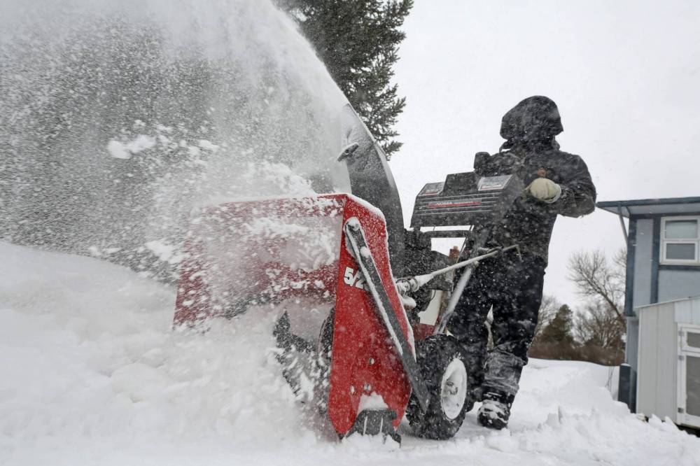 Centennial Drive resident Mathew Shewchuk in Minnedosa uses a snowblower to clear his driveway on Friday afternoon. The community received several centimetres of snow overnight Thursday from a large weather system that blew through the Prairies late this week and into Ontario. (Matt Goerzen/The Brandon Sun)