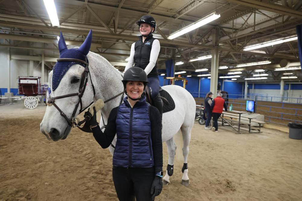 Curry Stables co-owner Kate Curry takes a picture with her daughter, Lillian (on the horse) at the Keystone Centre on Sunday afternoon.