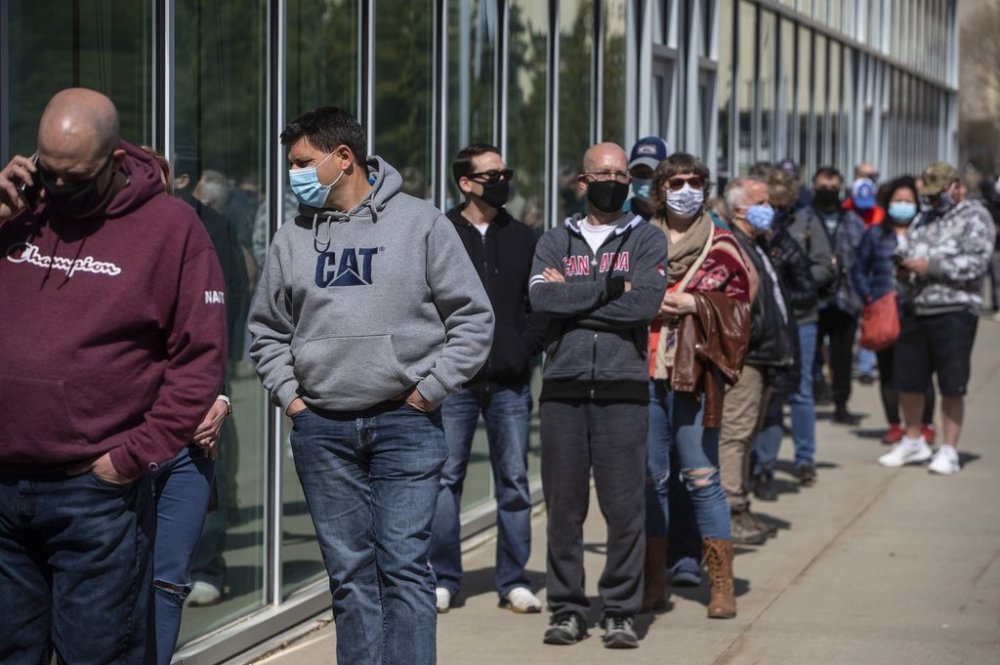 People line up outside an immunization clinic to get their Oxford-AstraZeneca COVID-19 vaccine in Edmonton, Tuesday, April 20, 2021. THE CANADIAN PRESS/Jason Franson
