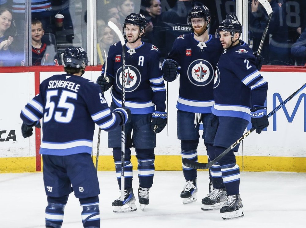 Winnipeg Jets' Mark Scheifele (55), Neal Pionk (4), Kyle Connor (81) and Dylan DeMelo (2) celebrate Connor's goal against the Dallas Stars during first period NHL action in Winnipeg on Friday, March 14, 2025. THE CANADIAN PRESS/John Woods
