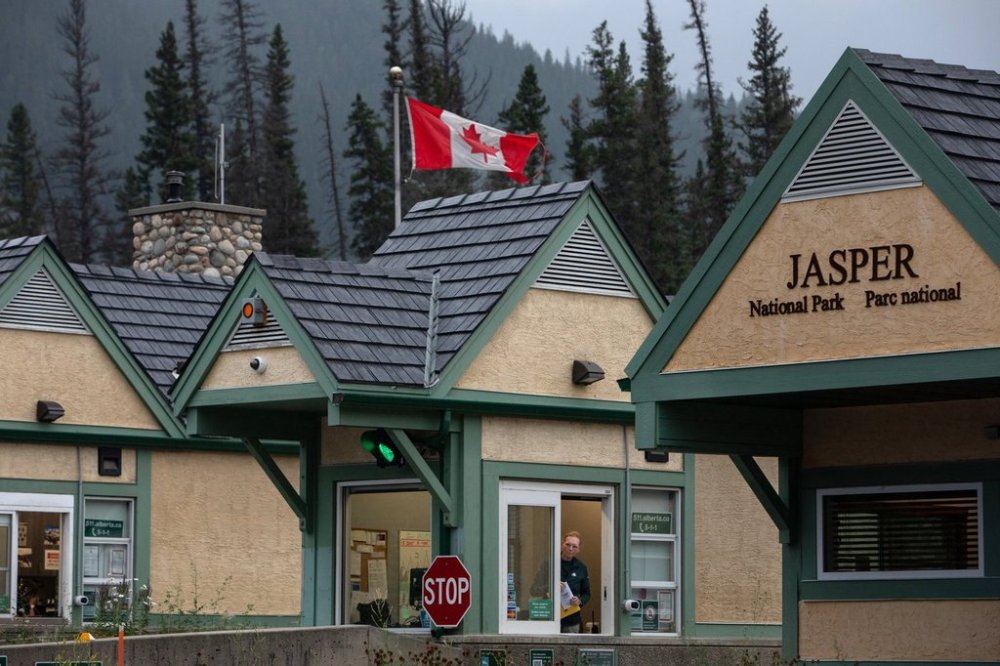 Police and Park rangers wait for residents at the park gates on the first day residents are able to visit their Jasper, Alta., properties on Friday, Aug. 16, 2024. Every summer for 61 years, tourists have piled onto Jasper’s SkyTram to see the town nestled inside the sprawling Rocky Mountains. THE CANADIAN PRESS/Amber Bracken