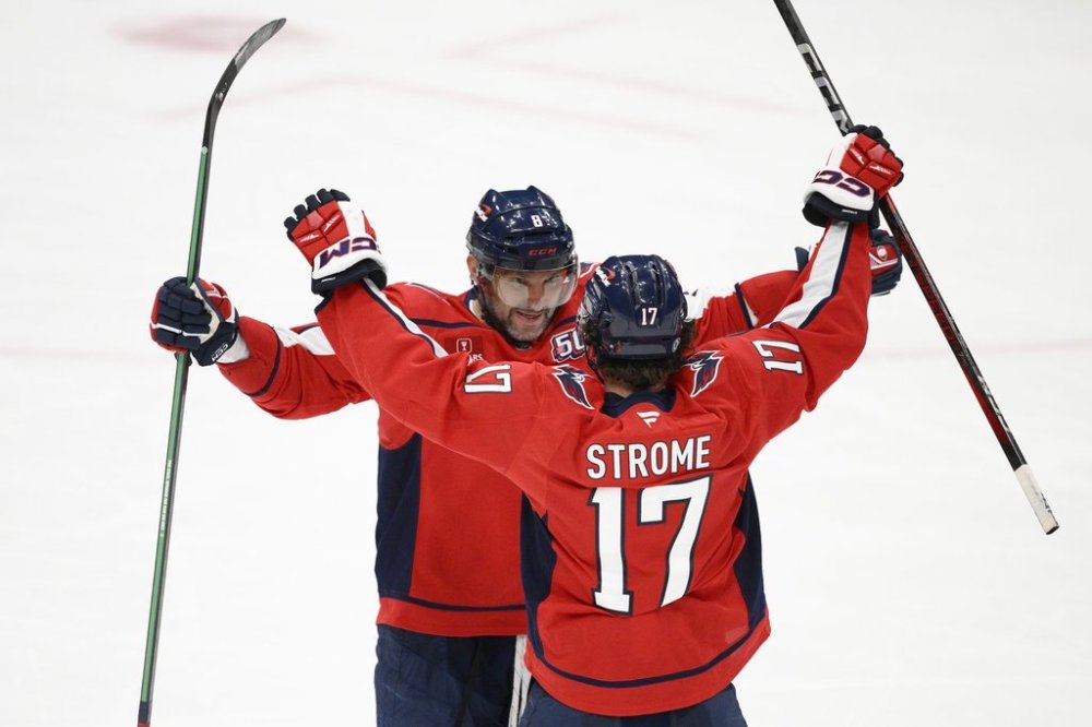 Washington Capitals left wing Alex Ovechkin (8) celebrates his empty-net goal for a hat trick with centre Dylan Strome (17) during the third period of an NHL hockey game against the Edmonton Oilers, Sunday, Feb. 23, 2025, in Washington. (AP Photo/Nick Wass)