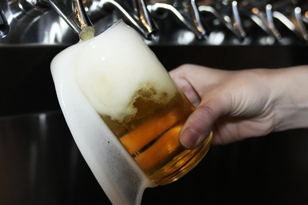 A stand off is brewing between Alberta's government and the province's biggest and oldest craft brewery as the company faces a sudden 22 per cent tax increase under a new provincial liquor fee rate — a rate that largely doesn't impact any other brewery. A bartender pours a craft beer in Buffalo Grove, Ill., Thursday, Feb. 9, 2022. THE CANADIAN PRESS/AP/Nam Y. Huh