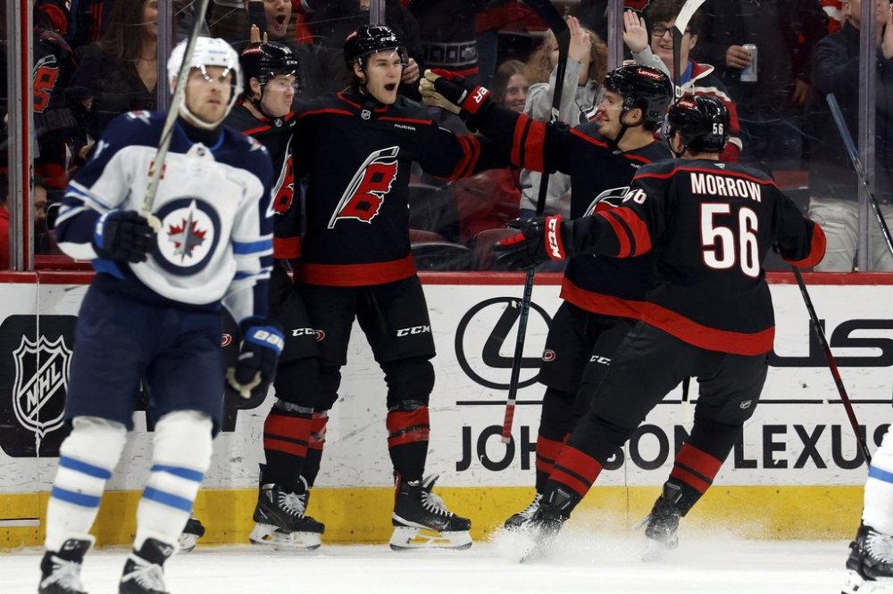 Carolina Hurricanes' Mark Jankowski, centre, celebrates with teammates after his goal against the Winnipeg Jets during the first period of an NHL hockey game in Raleigh, N.C., Sunday, March 9, 2025. (AP Photo/Karl DeBlaker)