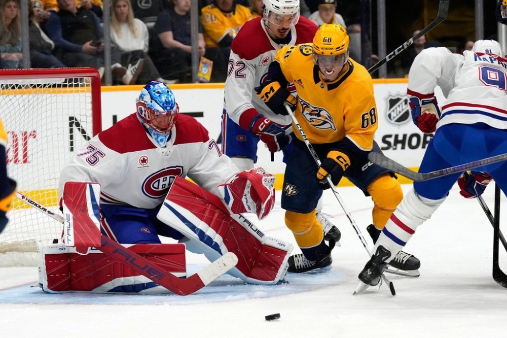 Nashville Predators left wing Zachary L'Heureux (68) and Montreal Canadiens goaltender Jakub Dobes (75) follow the puck during the second period of an NHL hockey game Sunday, April 6, 2025, in Nashville, Tenn. (AP Photo/Mark Humphrey)