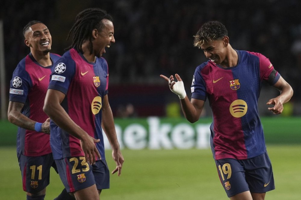 Barcelona's Lamine Yamal, right, celebrates with his teammates after scoring his side's second goal during the Champions League round of 16 second leg soccer match between FC Barcelona and SL Benfica at the Lluis Companys Olympic Stadium in Barcelona, Spain, Tuesday, March 11, 2025. (AP Photo/Emilio Morenatti)