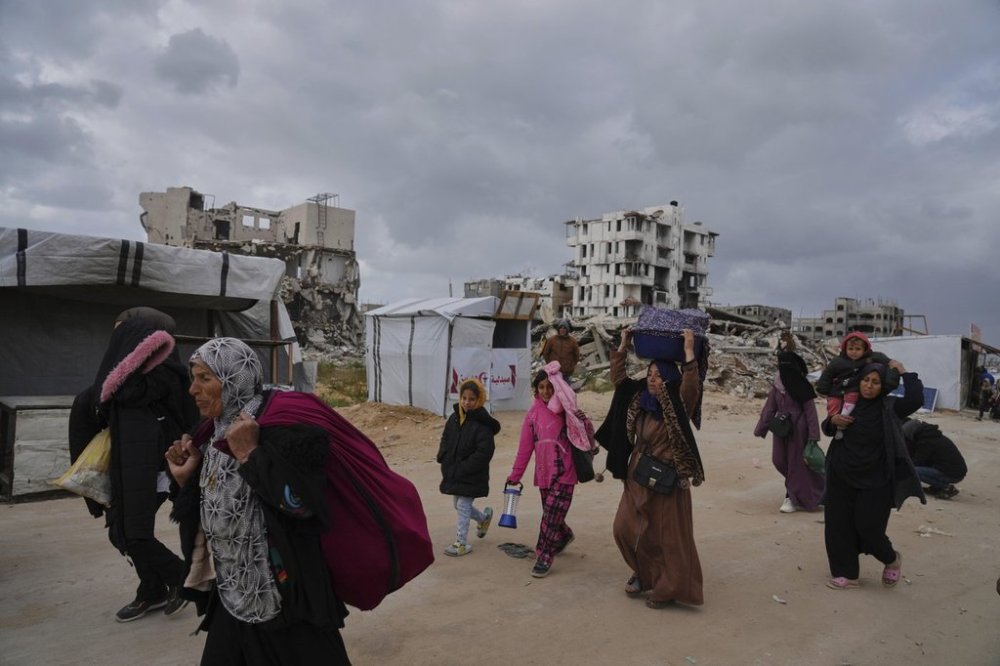 Displaced Palestinians, carrying their belongings, move away from the areas where the Israeli army is operating after Israel's renewed offensive in the Gaza Strip, on the outskirts of Beit Lahia, Thursday, March 20, 2025. (AP Photo/Jehad Alshrafi)