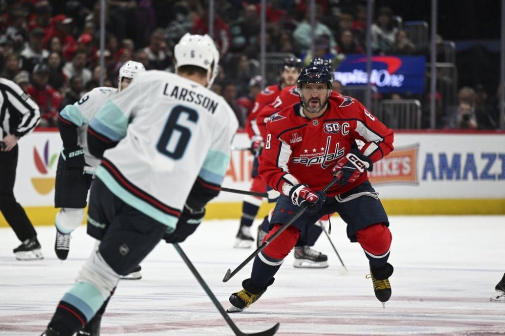 Washington Capitals left wing Alex Ovechkin (8) gets back on defence as Seattle Kraken defenceman Adam Larsson (6) skates with the puck during the first period of an NHL hockey game, Sunday, March 9, 2025, in Washington. (AP Photo/Terrance Williams)
