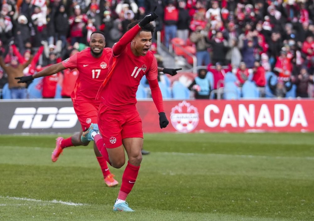 Team Canada’s Tajon Buchanan (11) celebrates his goal with teammate Cyle Larin after scoring against Jamaica during first half men's World Cup qualifier soccer action in Toronto on Sunday, March 27, 2022. THE CANADIAN PRESS/Nathan Denette