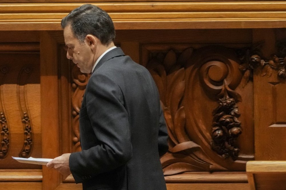 Portuguese Prime Minister Luis Montenegro walks back to his seat after delivering a speech during a debate preceding a confidence motion vote at the Portuguese parliament in Lisbon, Tuesday, March 11, 2025. (AP Photo/Armando Franca)