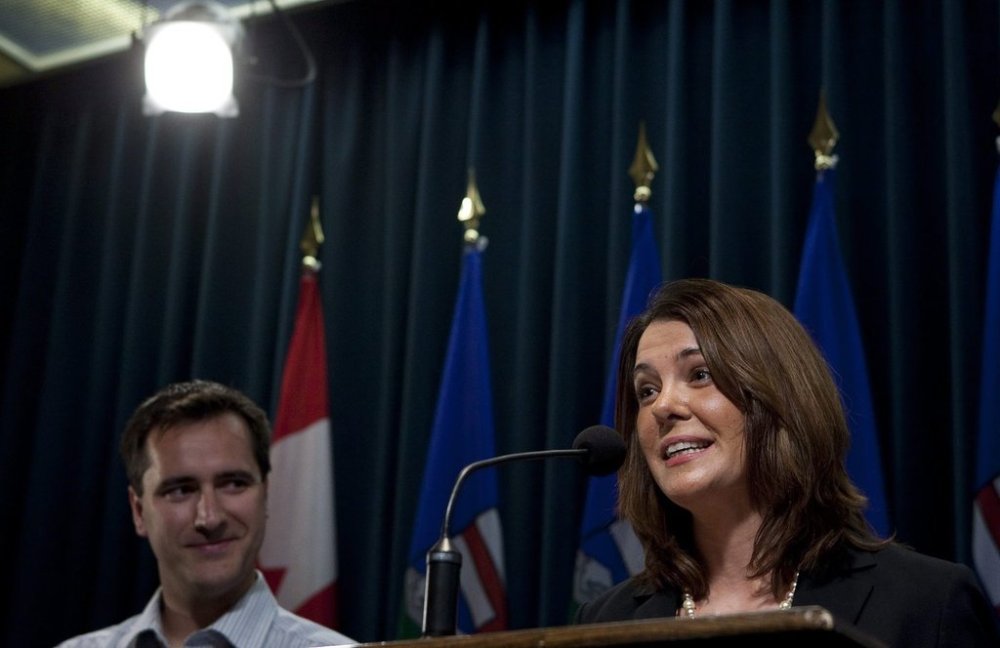 Alberta Premier Danielle Smith, right, speaks to reporters, as chief of staff Rob Anderson looks on in this file photo in Calgary, Alta., Wednesday, Jan. 26, 2011. Anderson is defending a business class flight he charged to taxpayers, citing a health condition that increases his risk of blood clots. THE CANADIAN PRESS/Jeff McIntosh