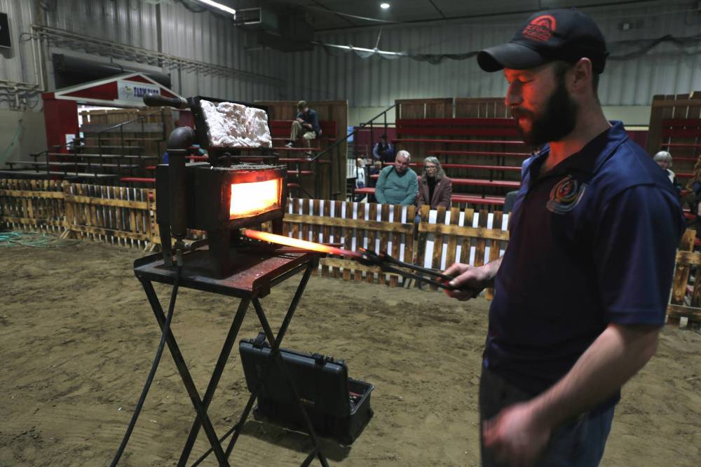 Brad Snyder pulls a bar of steel from his portable forge before his show at the Royal Manitoba Winter Fair on Thursday. Snyder demonstrated how he forges horseshoes in real-time for a crowd of about 60 people. (Photos by Connor McDowell/The Brandon Sun)