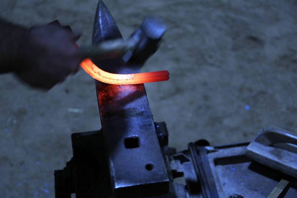 Snyder hammers a blazing hot bar of steel on his anvil at the Winter Fair on Thursday.