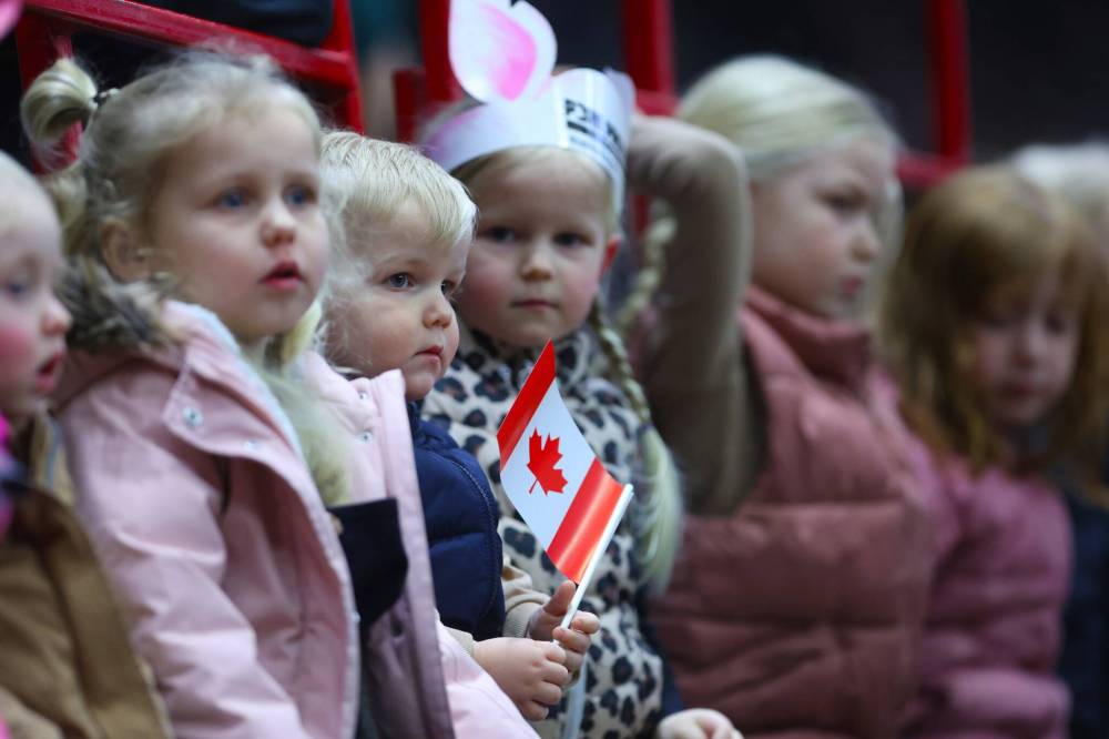 Two-year-old Winkler from Brandon holds a Canadian maple leaf flag while waiting for the Canine Circus performance to begin on Monday evening at the Westoba Place Arena during the opening night of the Royal Manitoba Winter Fair.