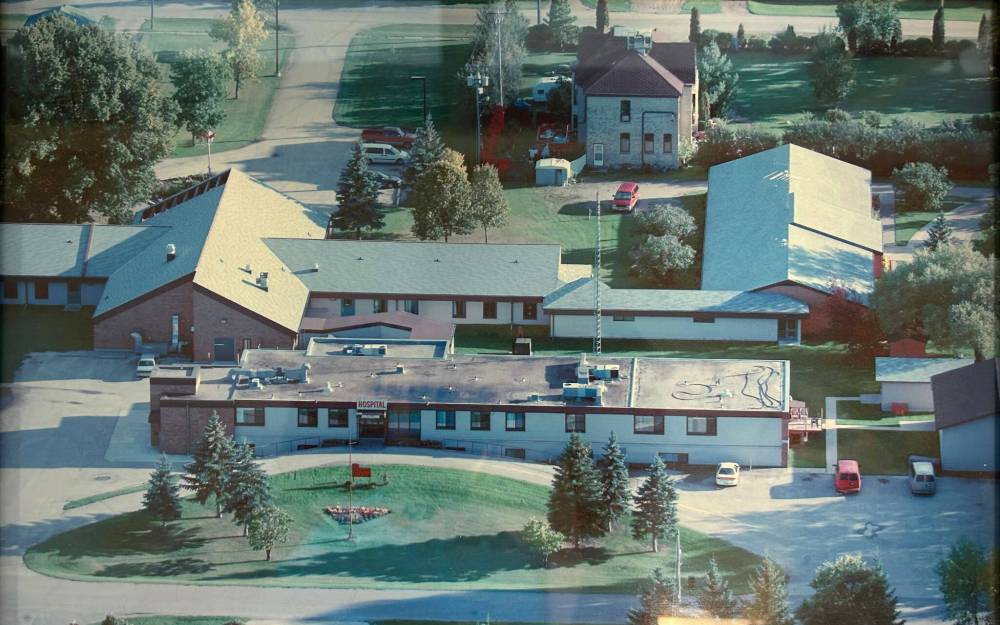 An aerial view of the Glenboro Health Centre (front with flat roof), which also houses the medical clinic in the basement. The peaked-building behind is the Glenboro Personal Care Home. The green space in the top right corner is where the new Spirit Sands Medical Clinic will be built. (File)