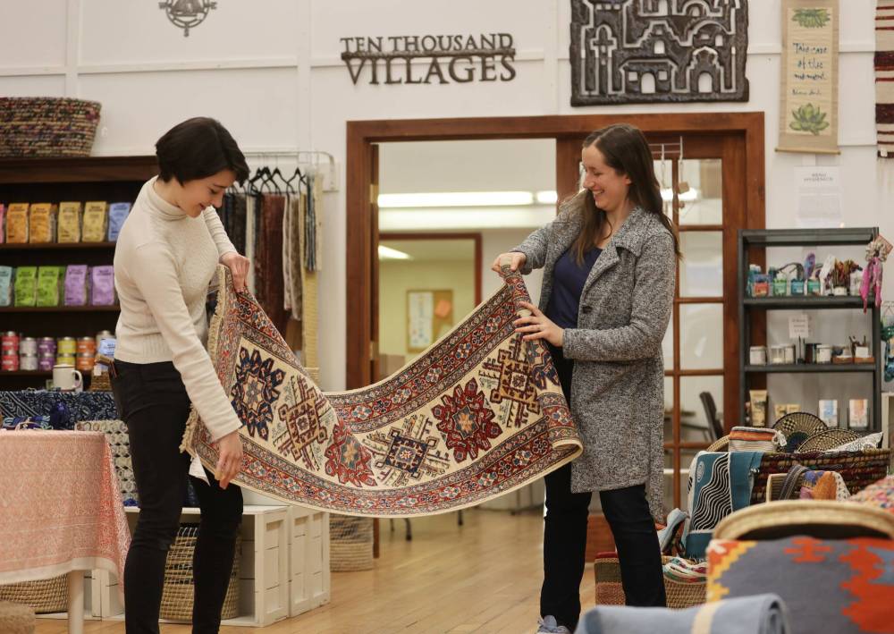 Julianna Murray (left), assistant manager at Ten Thousand Villages, examines a handmade fair trade runner rug with store manager Stephanie De la Luz ahead of last year’s Fair Trade Rug Event. This year’s Fair Trade Rug Event runs through May 10. (Michele McDougall/The Brandon Sun files)