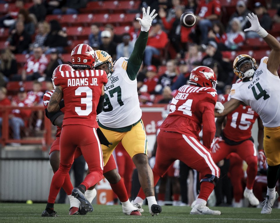 Edmonton Elks' Quincy Ledet, right, tries to block a pass from Calgary Stampeders quarterback Vernon Adams Jr. during first half CFL preseason football action in Calgary, Saturday, May 24, 2025. Adams Jr. and teammate Dominique Rhymes (15) have reunited as Calgary Stampeders after a season and a half as B.C. Lions teammates. THE CANADIAN PRESS/Jeff McIntosh