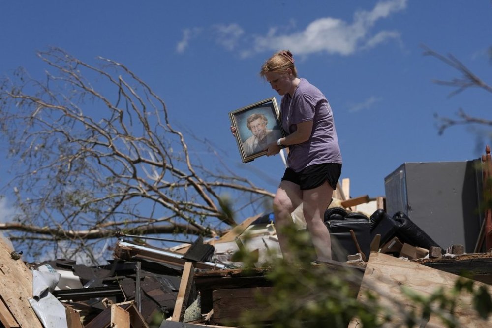 Hailee Allen holds a family picture saved from Lynn and Don White's home, Saturday, May 17, 2025, in London, Ky (AP Photo/Carolyn Kaster)