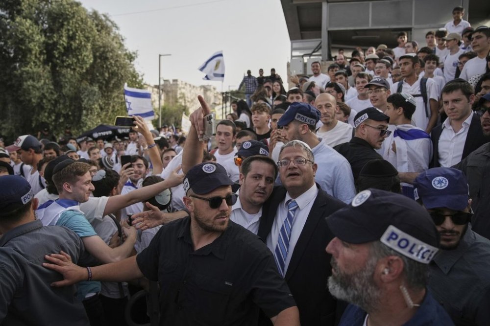 Surrounded by security guards, Israel's far-right National Security Minister, Itamar Ben-Gvir, center, participates in march marking Jerusalem Day, an Israeli holiday celebrating the capture of east Jerusalem in the 1967 Mideast war, in Damascus Gate of Jerusalem's Old City, Monday, May 26, 2025. (AP Photo/Leo Correa)