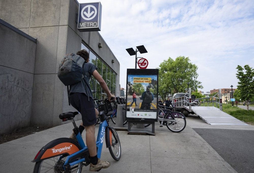 A Bixi bike rider pulls in to a Metro station prior to the restricted hours where metro and buses discontinue service due to the Société de transport de Montréal (STM) maintenance workers strike in Montreal on Monday, June 9, 2025. THE CANADIAN PRESS/Christinne Muschi
