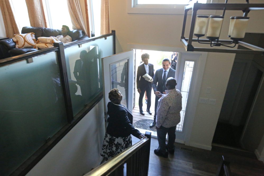 Helen and Onyebuchi Onuke greet Kinew and Asagwara in their Sprucewoods-area home on Thursday morning, while their son, Chinonso Onuke, waits on the couch upstairs. (Matt Goerzen/The Brandon Sun)