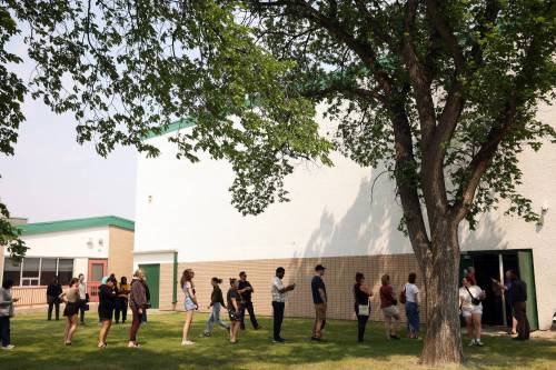 Parents and guardians queue to pick up students from École Secondaire Neelin High School’s gymnasium on Tuesday afternoon.
