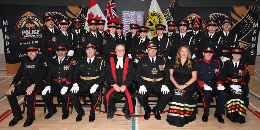 Fifteen new graduates from the MFNPS training program stand behind dignitaries at their ceremony in April. The addition of its own training program in 2024 is one sign of growth for the police service, which is also growing its staff and increasing the size of its headquarters this year. (Manitoba First Nations Police Service/Facebook)