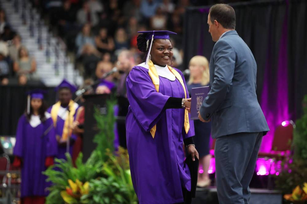 Grade 12 graduate Tope Ajayi receives her diploma during the ceremony. (Tim Smith/The Brandon Sun)