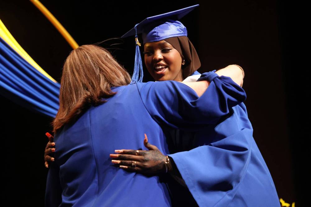 Graduate Tolsan Osman Kafal hugs principal Katherine MacFarlane while accepting her diploma at the Prairie Hope High School graduation in Brandon on Thursday. She was one of 54 people to receive a diploma. (Photos by Alex Lambert/The Brandon Sun)