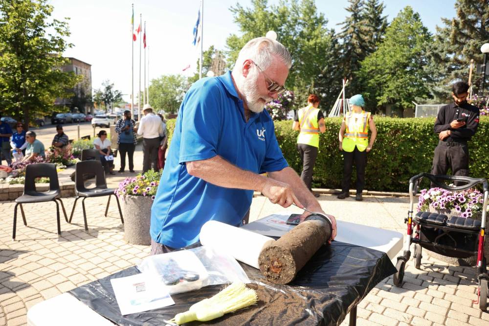 LEFT: Eldon Schmitz of the United Commercial Travelers prepares to open the time capsule on Friday. RIGHT: Former Brandon mayor Reg Atkinson looks at a Jan. 1, 2000 copy of The Brandon Sun at city hall on Friday morning. The newspaper was among the contents of the time capsule. (Tim Smith/The Brandon Sun)