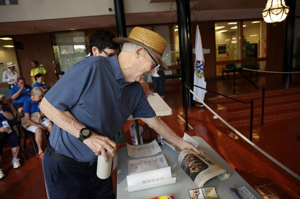 Former Brandon mayor Reg Atkinson looks at a Jan. 1, 2000 copy of The Brandon Sun at city hall on Friday morning. The newspaper was among the contents of the time capsule. (Tim Smith/The Brandon Sun)