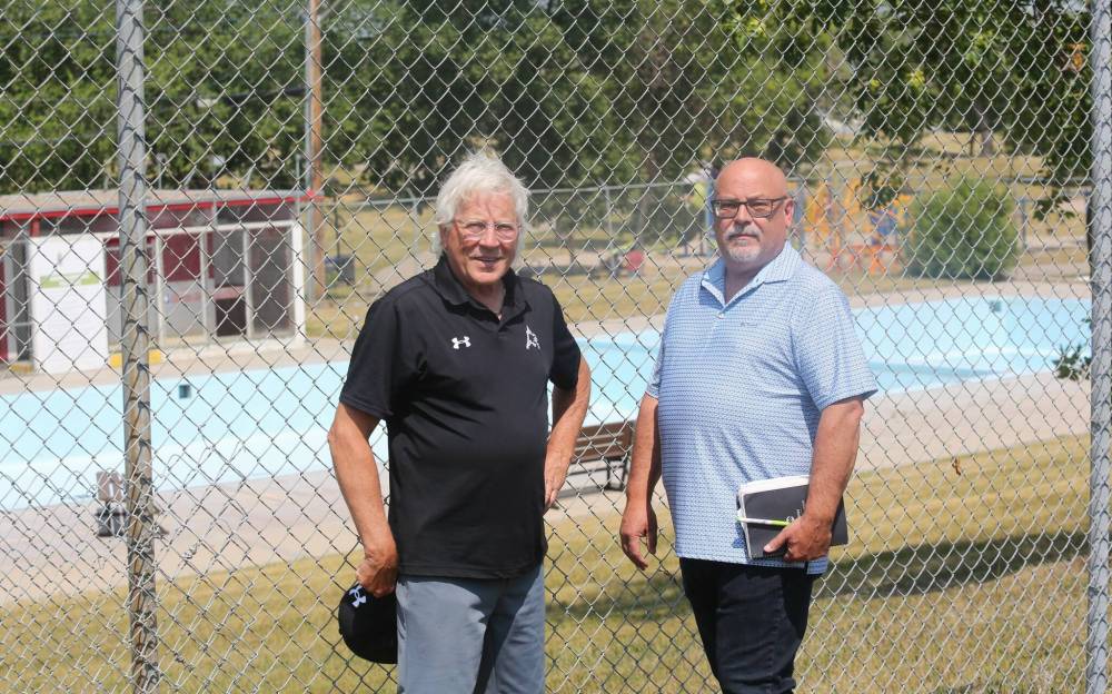 Brandon Ward 9 City Coun. Glen Parker (left) and general manager of operations Todd Burton stand outside the fence at the Kinsmen Pool in Rideau Park. (Michele McDougall/The Brandon Sun)