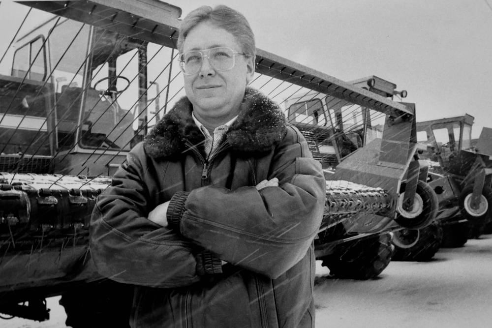 Brandon farm implement dealer Bob Mazer stands in front of a combine while the snow falls in this photo from 1988. (The Brandon Sun files)