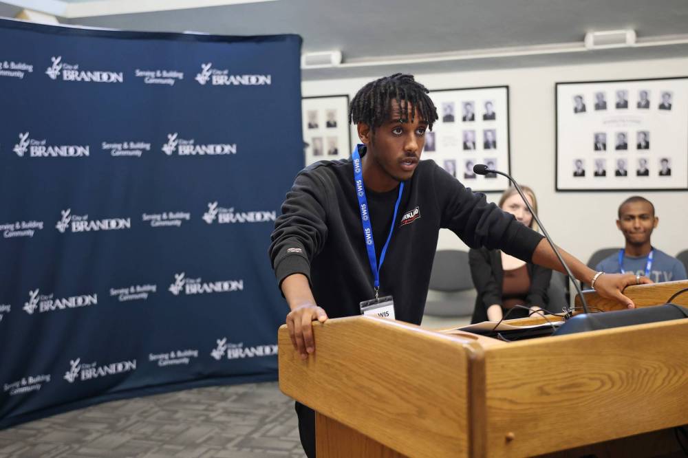 Youth Rise Leadership Program participant Adonay Legese speaks while taking part in a mock Brandon City Council meeting with fellow participants in council chambers. (Tim Smith/The Brandon Sun)