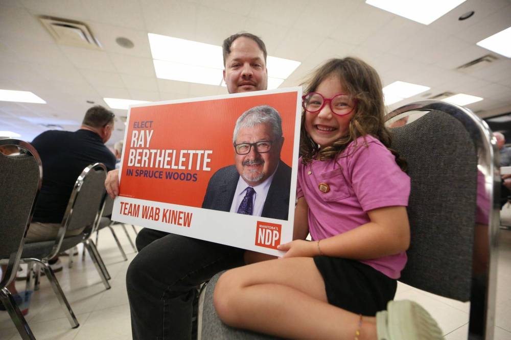 Five-year-old Maya Carr, daughter of Brandon School Division trustee Kirk Carr, smiles while helping her father hold an election sign for Spruce Woods NDP candidate Ray Berthelette during the party’s nomination announcement on Thursday afternoon. (Matt Goerzen/The Brandon Sun)
