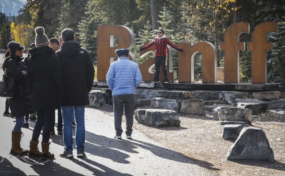 Tourists line up to pose for photos on the icon Banff sign in Banff, Alta., Thursday, Oct. 17, 2024. THE CANADIAN PRESS/Jeff McIntosh