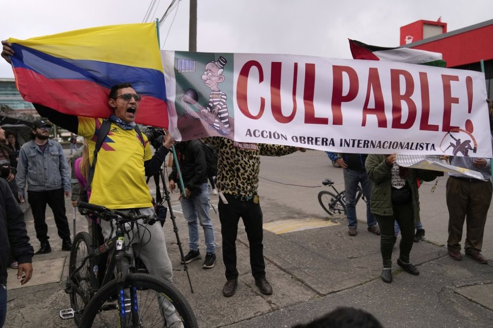 Opponents of former President Alvaro Uribe display a sign reading in Spanish
