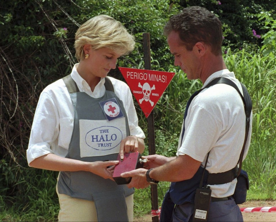 FILE - Diana, Princess of Wales, left, uses a remote switch to trigger the detonation of some explosive ordinance dug up by mine sweepers in Huambo, central Angola, Jan. 15, 1997. (AP Photo/Giovanni Diffidenti, File)