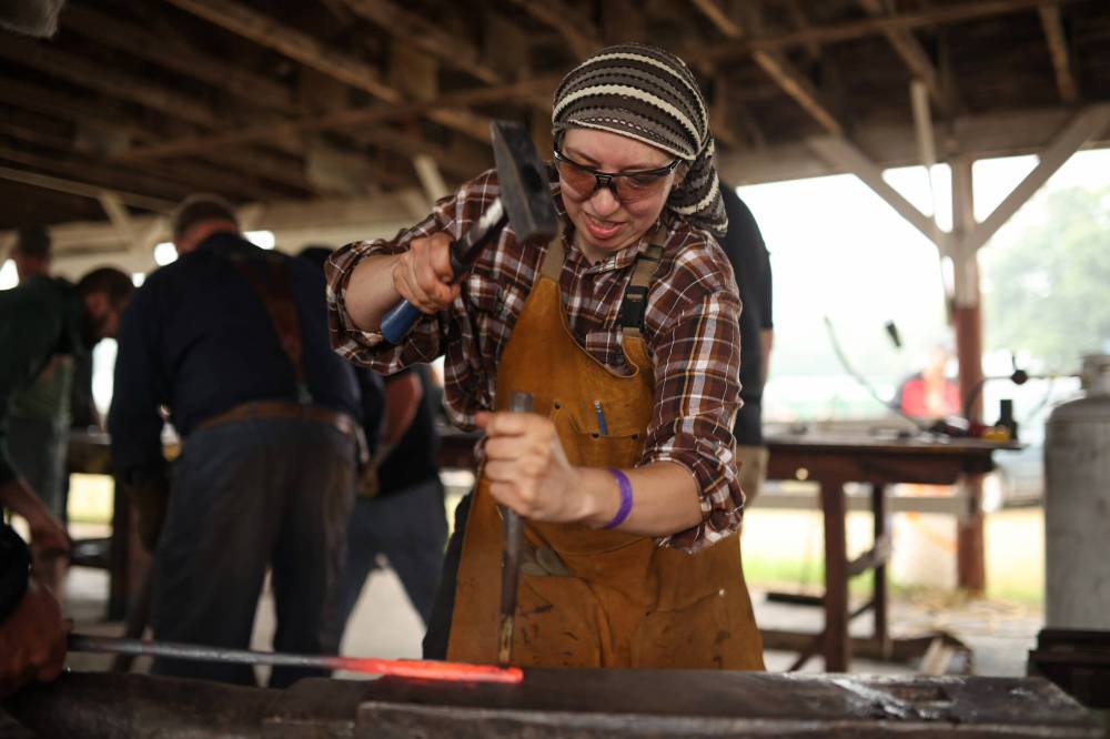 Sarah Wechsler of Nova Scotia works on a part of a collaborative metal sculpture during day two of the CanIRON XIV National Blacksmith Conference at the Manitoba Agricultural Museum south of Austin on Friday. Blacksmiths from across North America are in town for the four-day conference. Groups of blacksmiths worked together on Friday to create different pieces that will all go together to form a large sculpture.