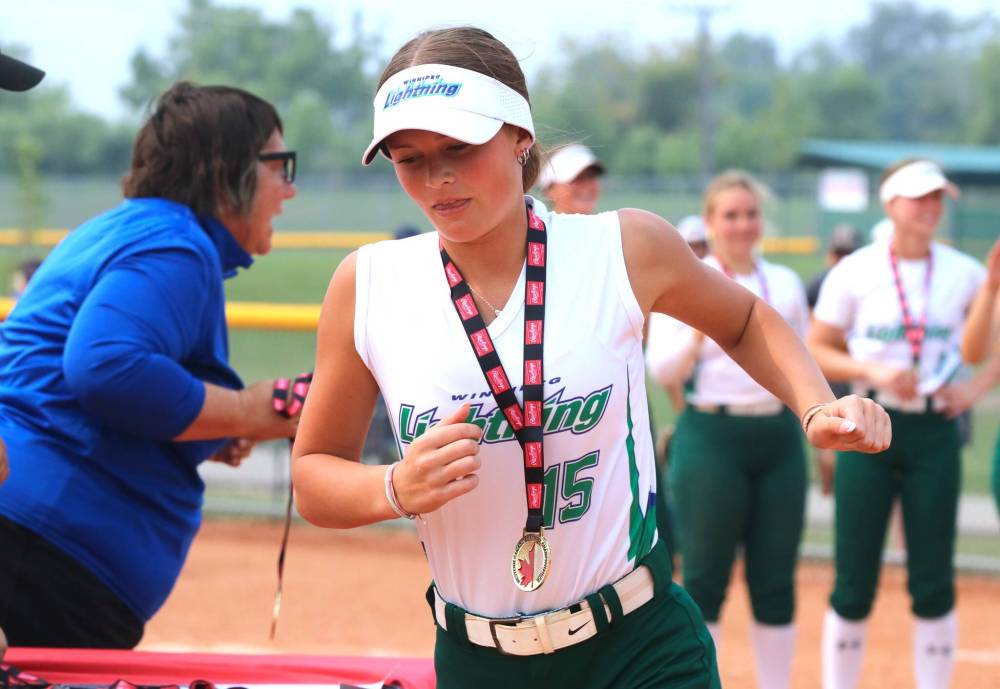 The lone Brandonite in the tournament was under-17 Westman Magic pickup Jade Campbell, shown with the gold medal she won with the Winnipeg Lightning as she heads over to shake hands with the Smitty's Terminators after the under-19 western Canadian softball championship final at Ashley Neufeld Softball Complex on Sunday. (Perry Bergson/The Brandon Sun)
