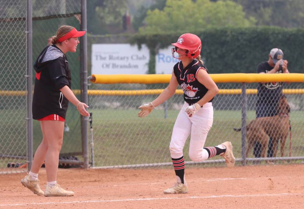 Smitty's Terminators coach Katherine Vigier congratulates Laura Venton after she hit a two-run homer in the bottom of the seventh inning to draw her team back within a run during the under-19 western Canadian softball championship final at Ashley Neufeld Softball Complex on Sunday. (Perry Bergson/The Brandon Sun)