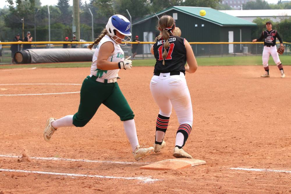 Winnipeg Lightning hitter Jenae Russell beats the throw to Smitty's Terminators first baseman Rielle McLeod as shortstop Jillian Matsubara watches during the under-19 western Canadian softball championship final at Ashley Neufeld Softball Complex on Sunday. (Perry Bergson/The Brandon Sun)