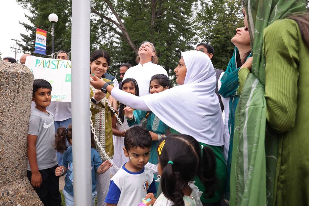 Members of Brandon’s Pakistani community, along with Brandon Mayor Jeff Fawcett, raise the Pakistan flag outside Brandon City Hall on Thursday to celebrate Pakistan’s Independence Day.