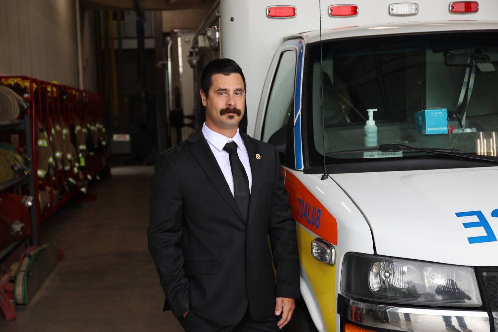 Brandon Professional Firefighter Paramedic Association president Gage Wood stands by an ambulance inside the fire hall garage on Sunday afternoon. (Abiola Odutola/The Brandon Sun)