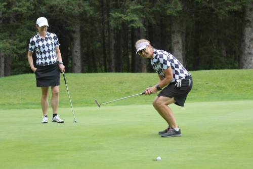 Kandis Matthews, right, sinks a birdie putt after teammate Dorelle Fulton chipped under a tree to within 10 feet of the hole on the par-5 14th hole during ladies scramble qualifying at the Tamarack golf tournament on Monday at Clear Lake Golf Course. (Thomas Friesen/The Brandon Sun)